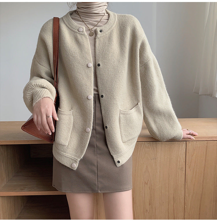 Person wearing a beige cardigan and skirt with a brown handbag indoors. Women's Soft Knit Crew Neck Cardigan – Oversized Button-Down Sweater with Pockets Cardigans mpncm1-10.myshopify.com womens-soft-knit-crew-neck-cardigan-pockets Fittyluxe