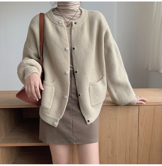 Person wearing a beige cardigan and skirt with a brown handbag indoors. Women's Soft Knit Crew Neck Cardigan – Oversized Button-Down Sweater with Pockets Cardigans mpncm1-10.myshopify.com womens-soft-knit-crew-neck-cardigan-pockets Fittyluxe