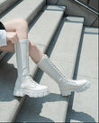 Person wearing white high-top sneakers sitting on a concrete step. Women's British Style Knee-High Platform Boots – Chunky Mid Heel Lace-Up Knee High Boots mpncm1-10.myshopify.com british-style-knee-high-platform-lace-up-boots-chunky Fittyluxe