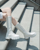 Person wearing white high-top sneakers sitting on a concrete step. Women's British Style Knee-High Platform Boots – Chunky Mid Heel Lace-Up Knee High Boots mpncm1-10.myshopify.com british-style-knee-high-platform-lace-up-boots-chunky Fittyluxe