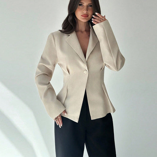 Woman wearing a beige blazer over a black top on a white background